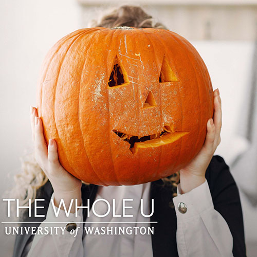 hands holding up a carved pumpkin